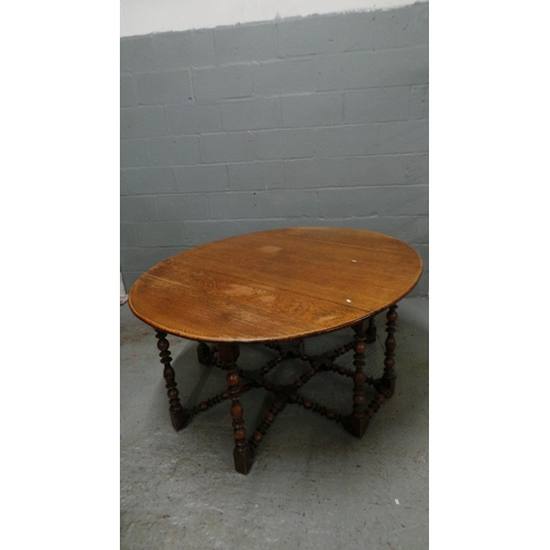 608 - An oak drop leaf dining table with bobbin style turned legs. It measures approx' closed 137 x 58 and... 
