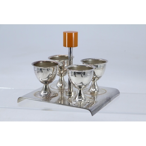 36 - Plated art deco egg stand and four egg cups with amber type bakelite handle