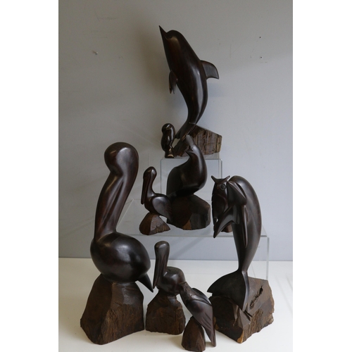 421 - Collection of nine hardwood carved figures of dolphins, birds etc