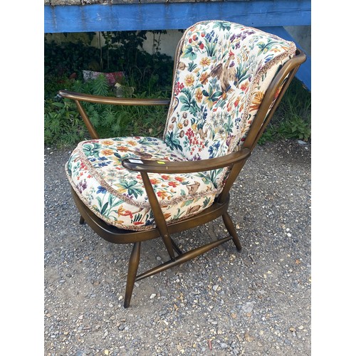 676 - Low Ercol arm chair, peacock patterned upholstery does not comply to recent fire and safety standard... 