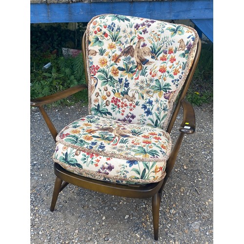 676 - Low Ercol arm chair, peacock patterned upholstery does not comply to recent fire and safety standard... 