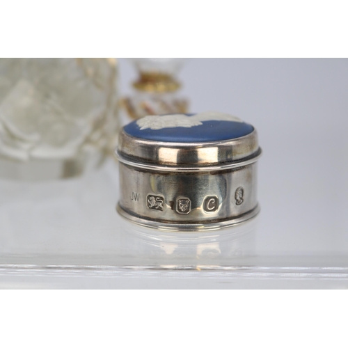 21 - Silver and enamel topped perfume bottle with stopper together with a glass perfume bottle and a silv... 