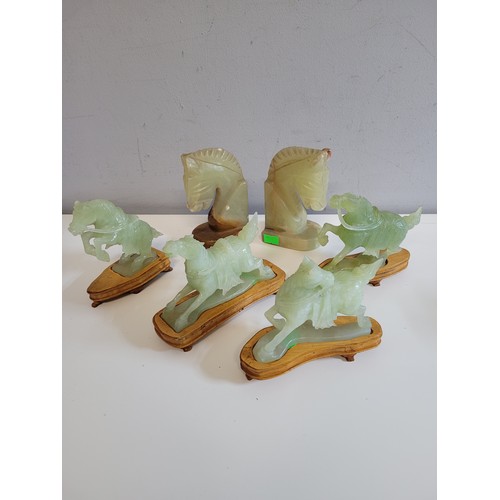 554 - Four carved Jadeite Chinese horses on wooden stands (inspect) with a pair of carved stone horse's he... 