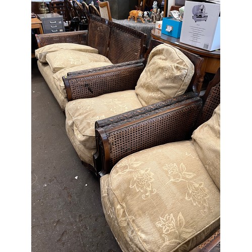 136 - Ercol, wooden framed begere settee and two armchairs, all with decorative carved frames. Note damage... 