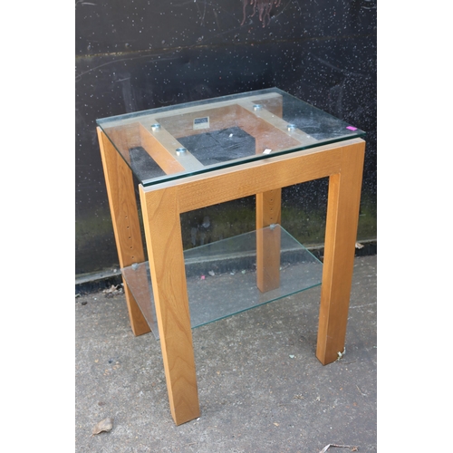 68 - An Ercol glass topped side table with adjustable shelf under. It measures approx. 50W x 40D x 67cmH ... 