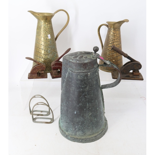 115 - An Arts & Crafts copper jug with two brass jugs, three embossing stamps and a stirrup.