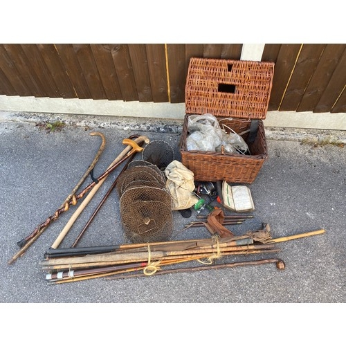 412 - A vintage wicker fishing box with reels, fly's, and other accessories together with split cane rods,... 