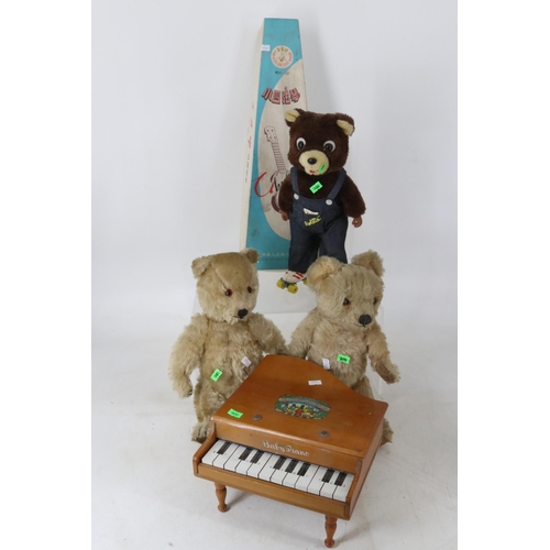 65 - Two vintage teddies, Rollies roller skating bear, boxed toy ukulele and a childs baby piano