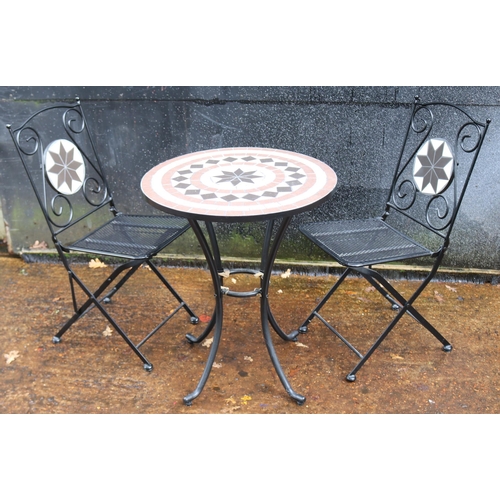 6 - Contemporary tiled top table together with two folding metal chairs, table measures approx in diamet... 