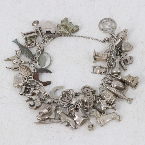 27 - Charm bracelet with approx 36 charms many of which are silver