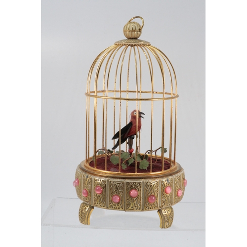 8 - Reuge of St Croix, musical bird in cage decorated pink stones to outer. Approx. height 24cm. winds w... 