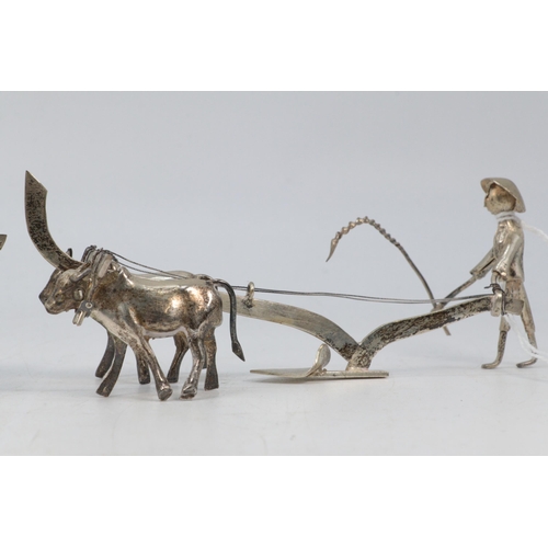 54 - Two Eastern white metal men ploughing. Size approx. 13cm long each