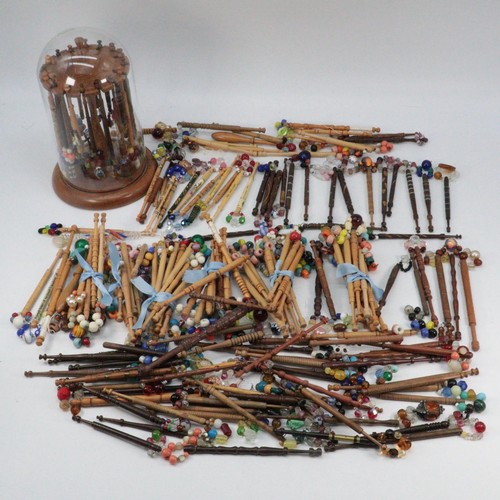 394 - An impressive collection of lace bobbins together with a wooden lace making stand with adjustable he... 