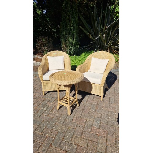 91 - Pair of wicker / Rattan armchairs with drop in seat pads and cushions. Together with a circular tabl... 