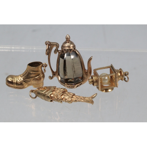 56 - A 9ct gold charms to include articulated fish, boot, lantern and a kettle with glass centre (approx.... 