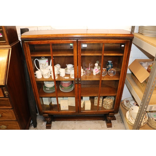 499 - An oak glazed door two door bookcase with three adjustable shelves