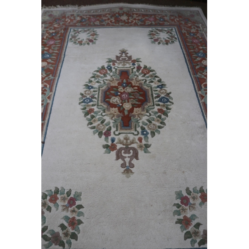 241 - Large oriental style rug with a cream ground measures approx. 273cm x 185cm