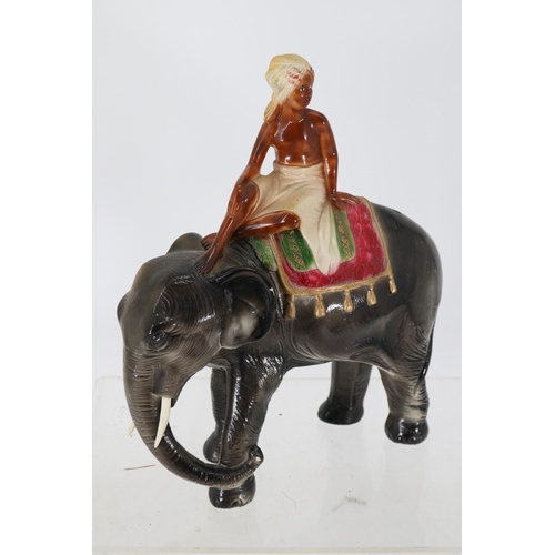 110 - Plaster elephant with boy seated to top measures approx. 35cm tall