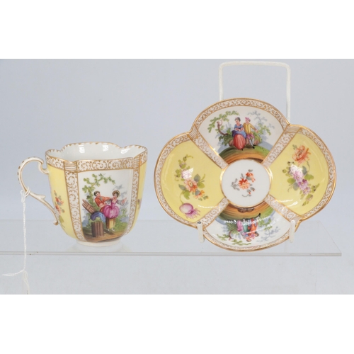 53 - A porcelain cup and saucer with decorative painted panels, marked Dresden to base