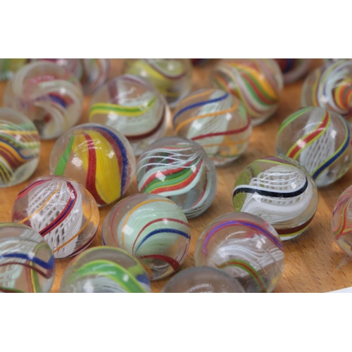 78 - Selection of antique twist marbles with a later solitaire board