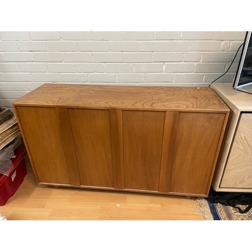 576 - An Ercol Windsor sideboard three cupboard doors over two drawers on castors (measures approx. W130cm... 