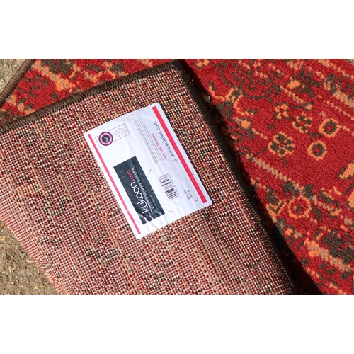 379 - A Kukoon rug with a red ground measuring approx. 151 x 228cm