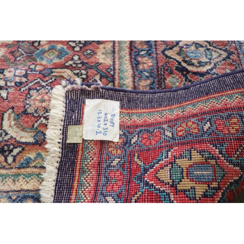 426 - A large rug with a blue ground, made in Iran, measuring approx. 305w x 399cml