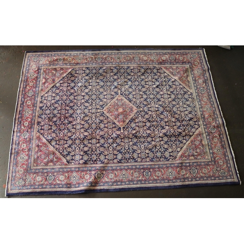 426 - A large rug with a blue ground, made in Iran, measuring approx. 305w x 399cml