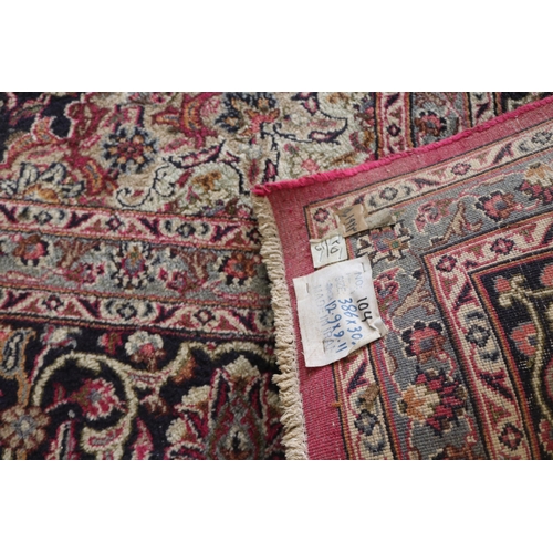 427 - A large rug with a red ground, made in Iran measuring approx. 298w x 386cmd