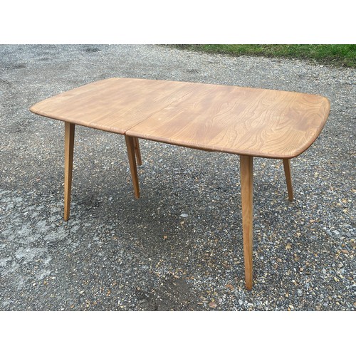 406 - Ercol extending dining table with fold out leaf stored under and fifth supporting leg together with ... 