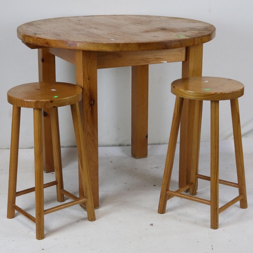 172 - Pine kitchen table with two stools measures approx. 90cm dia