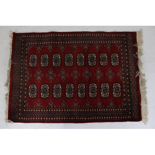 94 - An oriental rug with a red ground measuring approx. 80 x 112cm