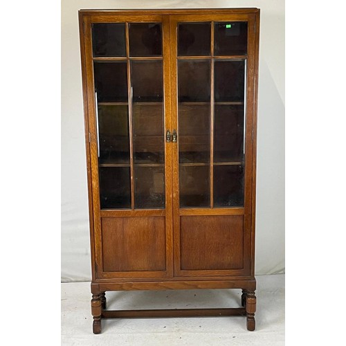 31 - Glazed bookcase over with cupboard under on base measures approx. 89cmW x 32cmD x 177cmH