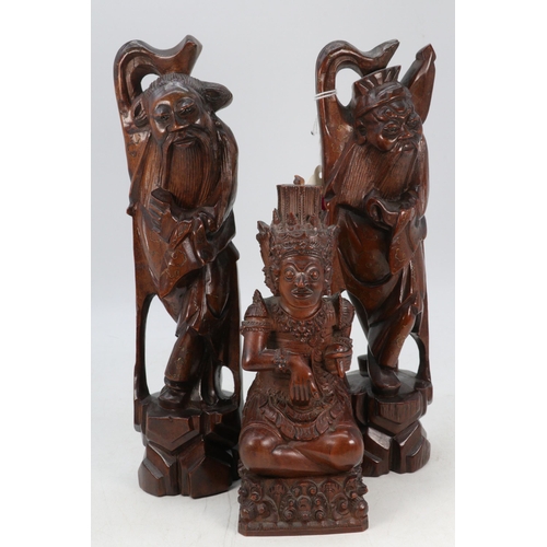 102 - A pair of carved oriental elders together with another similar