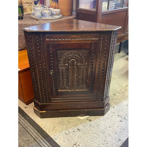 402 - An oak carved corner cupboard