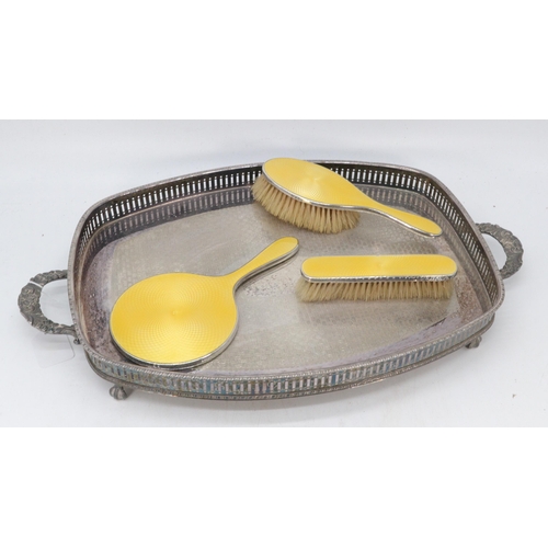 24 - Silver and yellow enamelled dressing table mirror and brushes together with a plated tray.