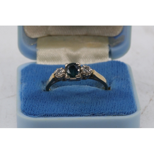 203 - 18ct gold ring set with central sapphire and two small illusion set diamond chips