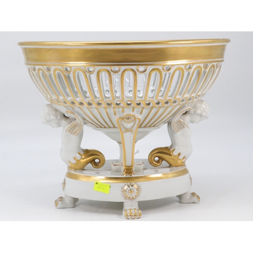 55 - Fine porcelain table centrepiece with a pierced basket supported by Cherubs on lion pad feet. Approx... 