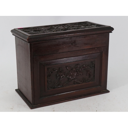 25 - An oriental style smokers cabinet with carvings of dragons to the  lift-up lid and revolving inner w... 