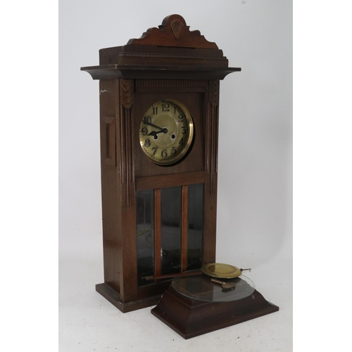 261 - A continental wall clock with pendulum and key. It measures approx. 39w x 19d x 58cmh. It comes with... 