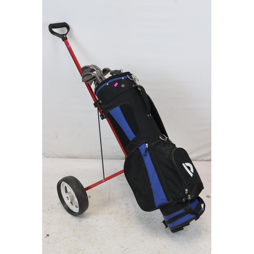 276 - A golf trolley with an assortment of clubs.