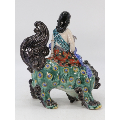 63 - Oriental figure riding a mystical Qillin, (approx. 23cm tall) with original bill of sale