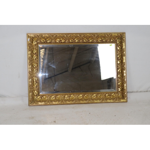 49 - Bevel edged mirror in gilt frame with grape decoration measures approx. 87cm x 62cm