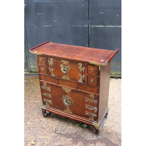 149 - Contemporary oriental cupboard with hidden drawers and brass embellishments, measures approx. 72cmW ... 