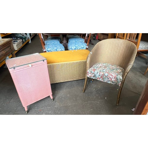 118 - A Lloyd Loom gold painted linen basket together with a similar chair and a loom style small pink lin... 