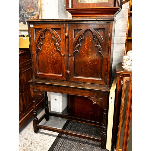 475 - An oak gothic carved cupboard on stand