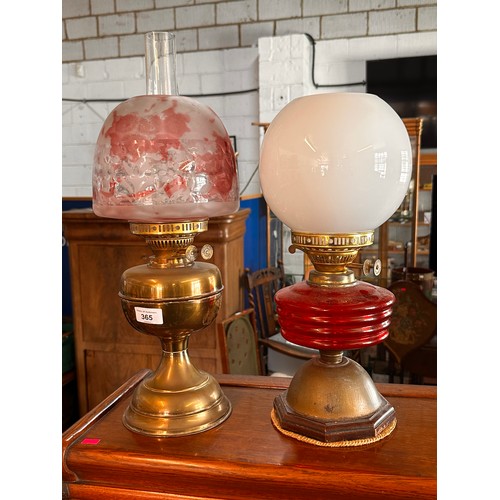 365 - A Vintage brass oil lamp with chimney and shade together with another similar converted to electric ... 