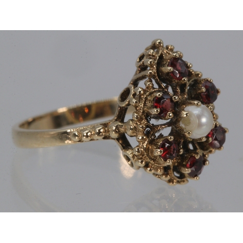 217 - A 9ct gold ring set with central seed pearl and surrounded by 6 small garnets, approx. weight 3.4g