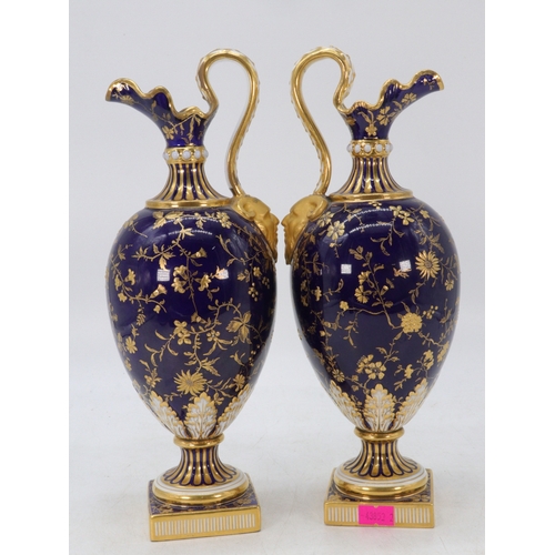 176 - A pair of Minton Ewers decorated cobalt ground with raised gilt decorated and two oval hand pained p... 