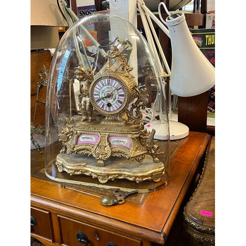 584 - Gilt spelter mantle clock with porcelain panels and a glass dome with pendulum and key (dome approx.... 